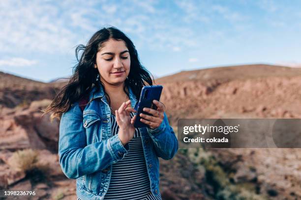 woman using cell phone on desert area - remote location phone stock pictures, royalty-free photos & images