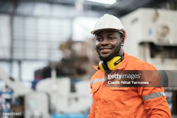 improving skills for an advanced manufacturing workforce. portrait of a male african american manufacturing process engineer is working in an auto parts production line. he is skilled in production line process design. - regular guy stock pictures, royalty-free photos & images