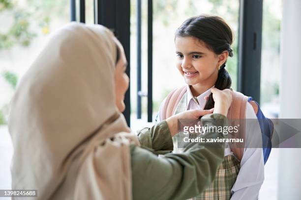 saudische mutter bereitet kleine tochter auf die schule vor - saudi youth stock-fotos und bilder