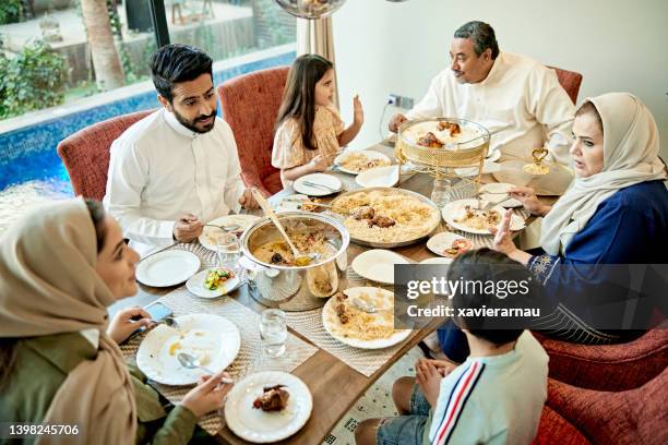 conversations during riyadh family midday meal - haleem stock pictures, royalty-free photos & images
