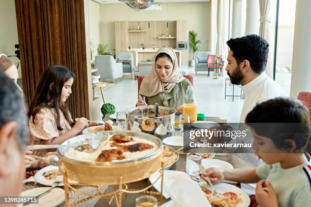 young saudi family and relatives enjoying midday meal - saudi food stock pictures, royalty-free photos & images