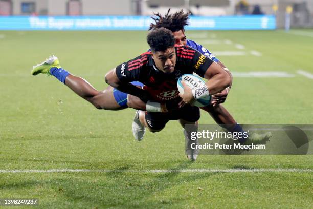 Leicester Fainga'anuku of the Crusaders scores a try against Selestino Ravutaumada of the Fijian Drua during the round 14 Super Rugby Pacific match...