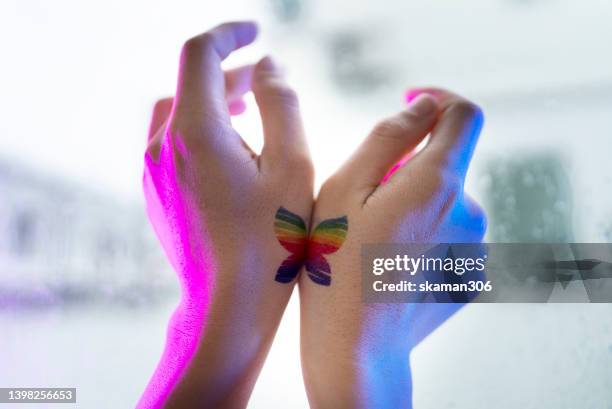 butterfly tattoo on hands rise up , and pose bird flying rainbow is lgbtq symbol, homosexual lovers - tattoos of butterfly stock pictures, royalty-free photos & images