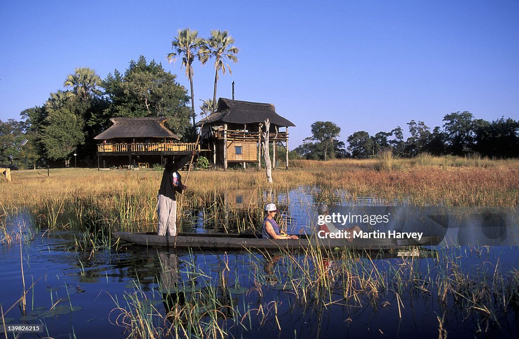TOURISTS FROM GUNN S CAMP, VIEW THE OKOVANGO DELTA FROM A MOKORO. BOTSWANA.