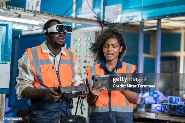 ai and machine learning can be improve productivity in manufacturing industry. female mechanical engineer and robotic welding operator. they are using vr glasses to simulation assembly welding before starting the actual production process. - personal perspective or pov stock-fotos und bilder