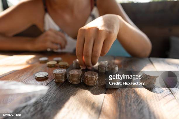 unrecognizable woman counting thai baht coins - counting stock pictures, royalty-free photos & images