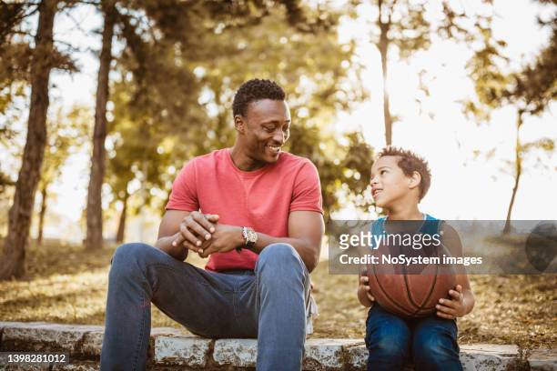 father and son talking about basketball - uncle nephew stock pictures, royalty-free photos & images
