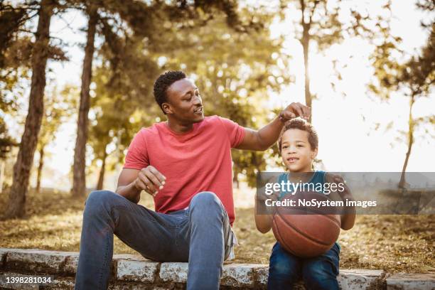 father and son talking about basketball - uncle nephew stock pictures, royalty-free photos & images