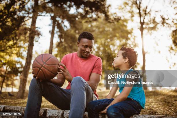 father and son talking about basketball - uncle nephew stock pictures, royalty-free photos & images