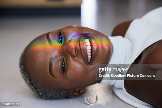 rainbow colored light refracting onto the face of a smiling woman - rainbow light reflection stock pictures, royalty-free photos & images