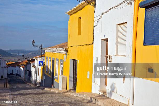 sun shining on walls of cobblestone street in silves, former capital of the moorish province of algarve, portugal - silves portugal stock pictures, royalty-free photos & images