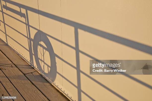 shadows of rail and life preserver on superstructure of sailboat - boat deck background stock pictures, royalty-free photos & images