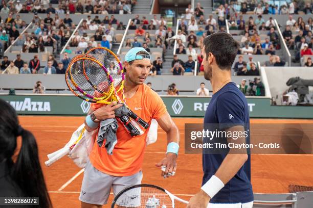 May 20. Rafael Nadal of Spain and Novak Djokovic of Serbia greet each other during training change over on Court Philippe Chatrier as players train...