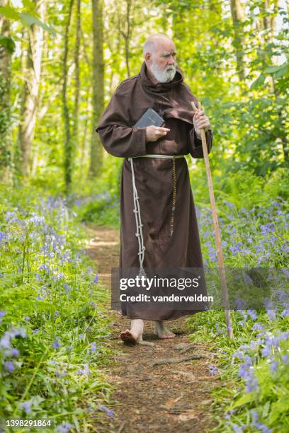 monje anciano caminando por el bosque - cristiano fotografías e imágenes de stock