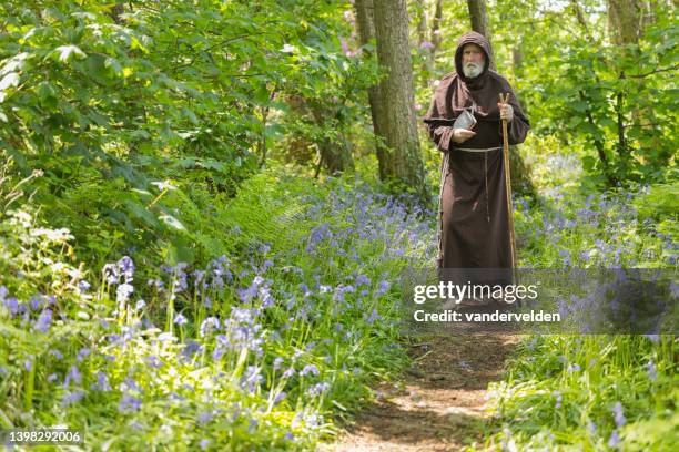 elderly monk walking in the woods - bluebell stock pictures, royalty-free photos & images