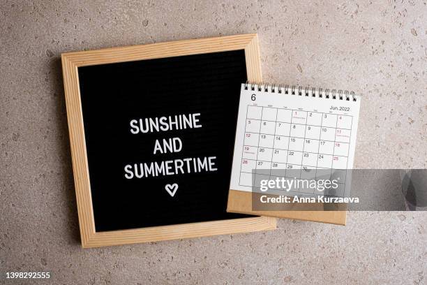 close-up of letter board with text “sunshine and summertime” and june 2022 desk calendar, top view. hello summer concept. - monday quotes stock pictures, royalty-free photos & images