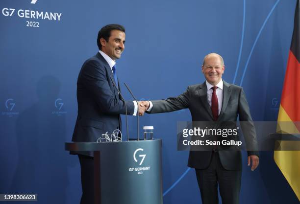 German Chancellor Olaf Scholz and Sheikh Tamim bin Hamad al Thani, Emir of Qatar, shake hands after speaking to the media following talks at the...