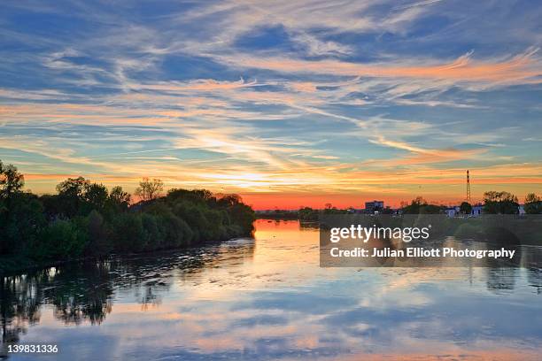 looking down the river cher in tours, france. the small town of la riche can be seen in the background under a stunning sunset. - indre et loire stock-fotos und bilder