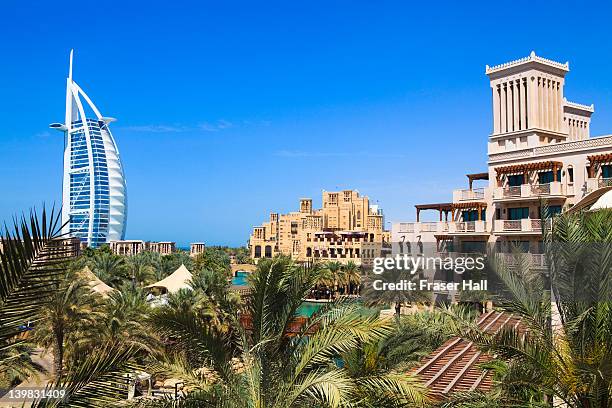 burj al arab and madinat jumeirah in foreground, the iconic burj al arab is the world's tallest hotel at 321 metres, jumeirah, dubai, united arab emirates - jumeirah beach stock pictures, royalty-free photos & images