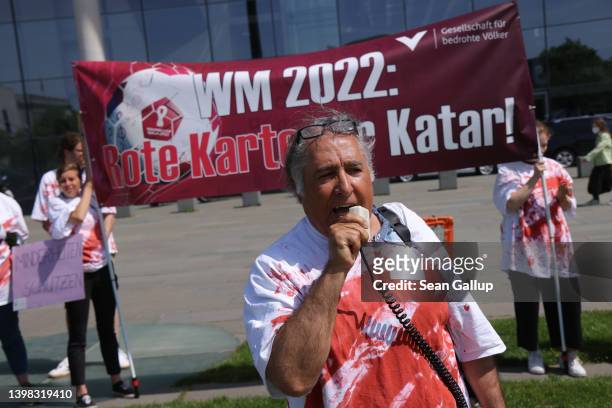 Protesters demonstrating against the visit of Sheikh Tamim bin Hamad al Thani, Emir of Qatar, stand opposite the Chancellery on May 20, 2022 in...