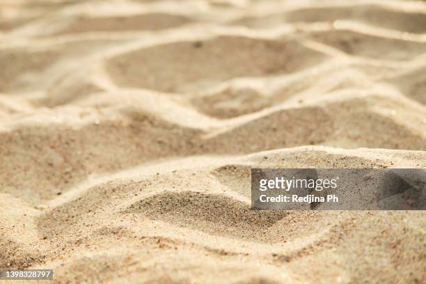 background texture of golden sand on the sea or ocean close up - champagnekleurig stockfoto's en -beelden