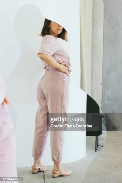 a young woman and the mirror. - woman-looking-into-mirror-full-body stock pictures, royalty-free photos & images