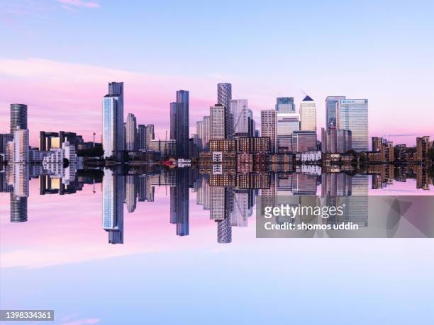 mirror image of london canary wharf skyline at dusk - digital composite - canary wharf stock-fotos und bilder