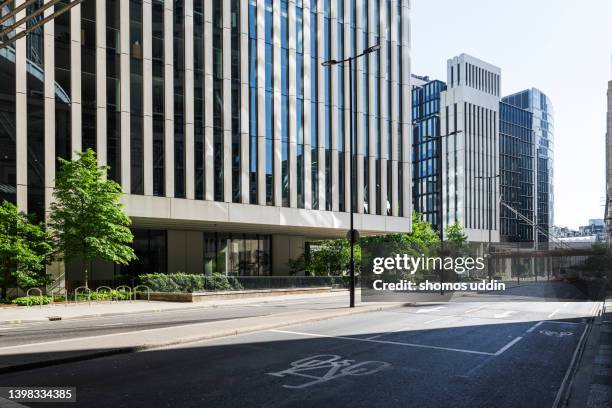 empty street amidst buildings in london financial district - empty street stock pictures, royalty-free photos & images