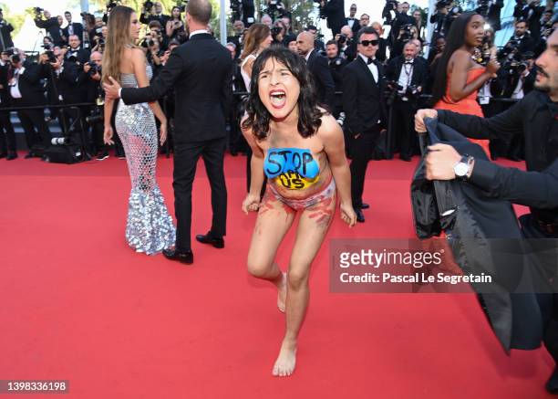 Protester makes her way onto the red carpet during the "Three Thousand Years Of Longing " Red Carpet during the 75th annual Cannes film festival at...