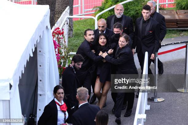 Security remove a protester from the red carpet during the "Three Thousand Years Of Longing " Red Carpet during the 75th annual Cannes film festival...