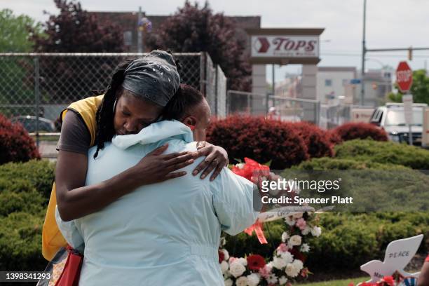 People embrace near a memorial for the shooting victims outside of Tops grocery store on May 20, 2022 in Buffalo, New York. 18-year-old Payton...