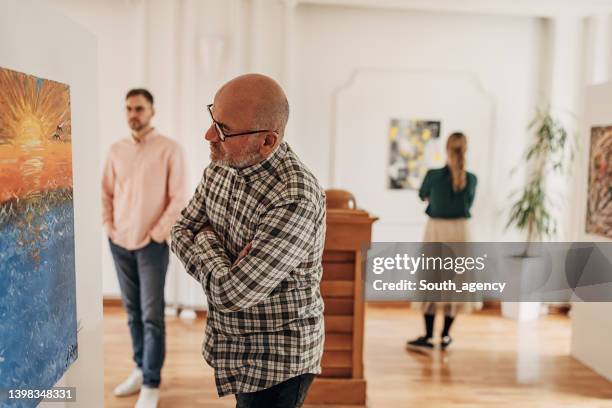 hombre disfrutando del arte - inauguración-de-galería fotografías e imágenes de stock