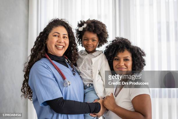 portrait of nurse with mother and daughter - family pediatrician stock pictures, royalty-free photos & images
