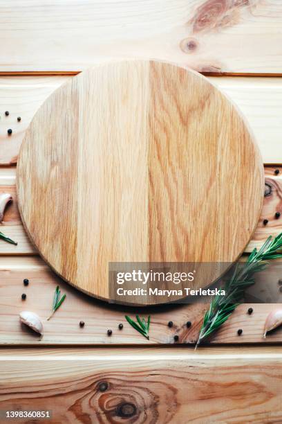 round cutting board with spices on a wooden background. place for food such as meat, burger, vegetables, grill, snacks, sandwich and the like. - teller von oben leer stock-fotos und bilder