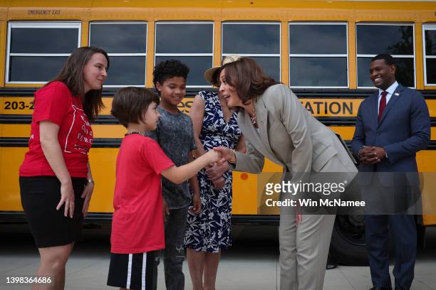 Vice President Kamala Harris greets young students with EPA Administrator Michael Regan while touring new electric powered school buses during a...