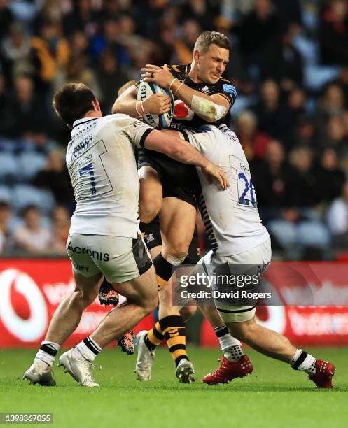 Jimmy Gopperth of Wasps is tackled by Tom Curry and Ben Curry of Sale Sharks during the Gallagher Premiership Rugby match between Wasps and Sale...