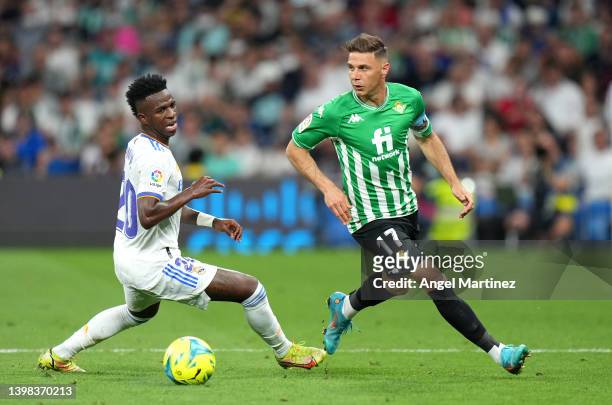 Vinicius Junior of Real Madrid battles for possession with Joaquin of Real Betis during the LaLiga Santander match between Real Madrid CF and Real...