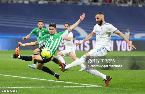 Karim Benzema of Real Madrid is challenged by Marc Bartra of Real Betis during the LaLiga Santander match between Real Madrid CF and Real Betis at...