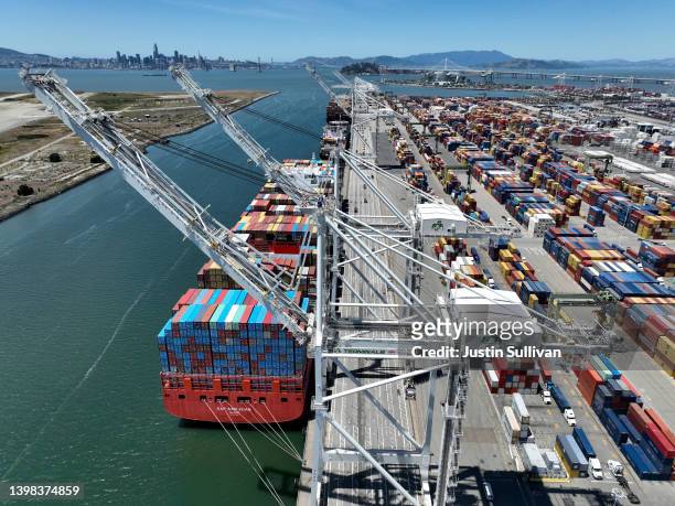 In an aerial view, a container ship sits docked at the Port of Oakland on May 20, 2022 in Oakland, California. As China begins to lift COVID-19...