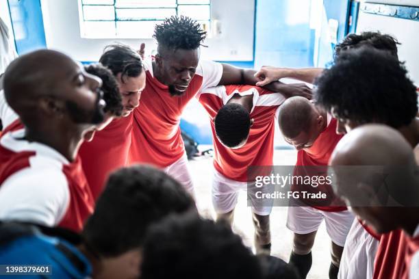soccer players huddling before a match in the locker room - locker room stock pictures, royalty-free photos & images