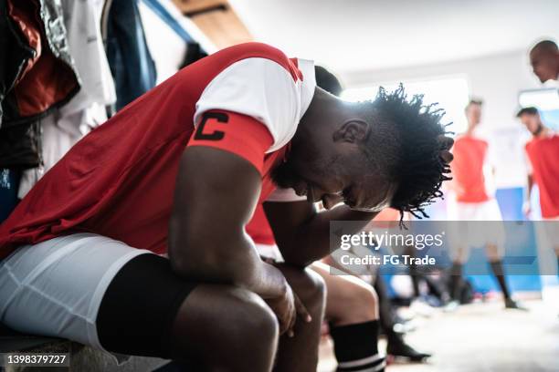 worried soccer player in the locker room - defeat stock pictures, royalty-free photos & images