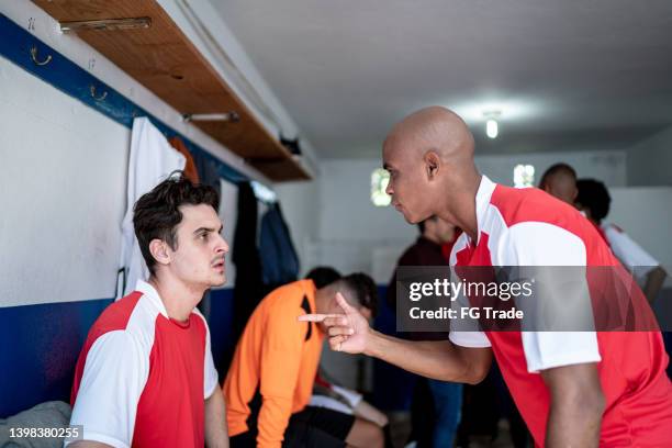 soccer players discussing in the locker room - blame game stock pictures, royalty-free photos & images