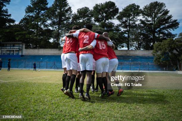 soccer players celebrating a goal - huddling stock pictures, royalty-free photos & images