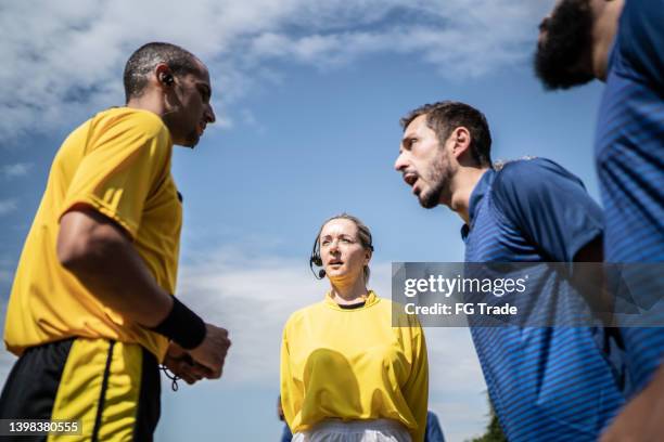 soccer players complaining to referee during match - female umpire stockfoto's en -beelden