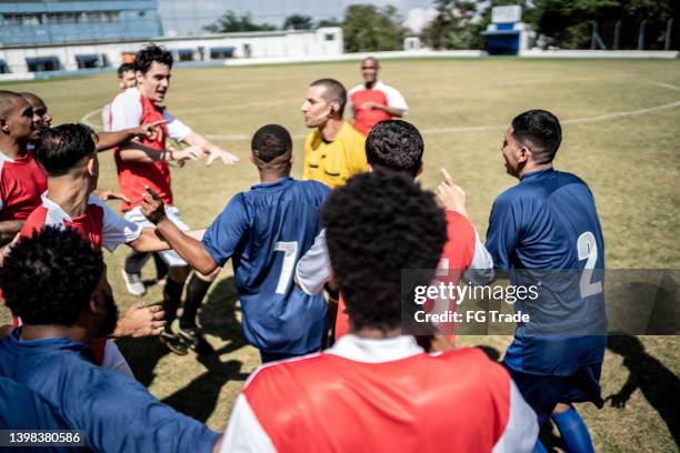 futbolistas quejándose al árbitro durante el partido - attack sporting position fotografías e imágenes de stock