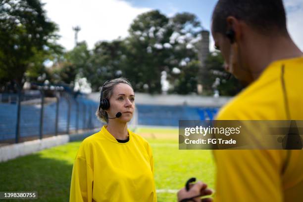 referees talking on the soccer field - female umpire stockfoto's en -beelden