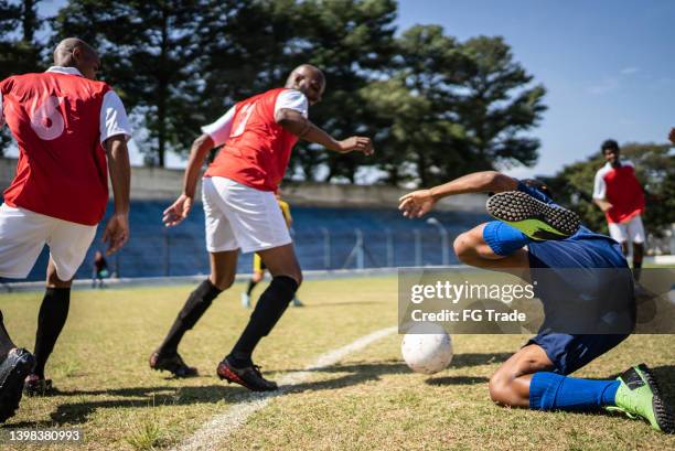 soccer player on the floor after a foul - attack sporting position stockfoto's en -beelden