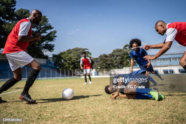 soccer player on the floor after a foul - attack sporting position stock pictures, royalty-free photos & images