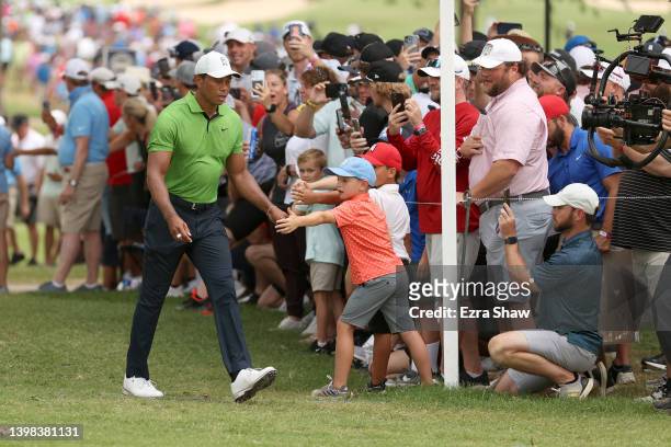 Tiger Woods of the United States greats fans as he walks to the 14th hole during the second round of the 2022 PGA Championship at Southern Hills...