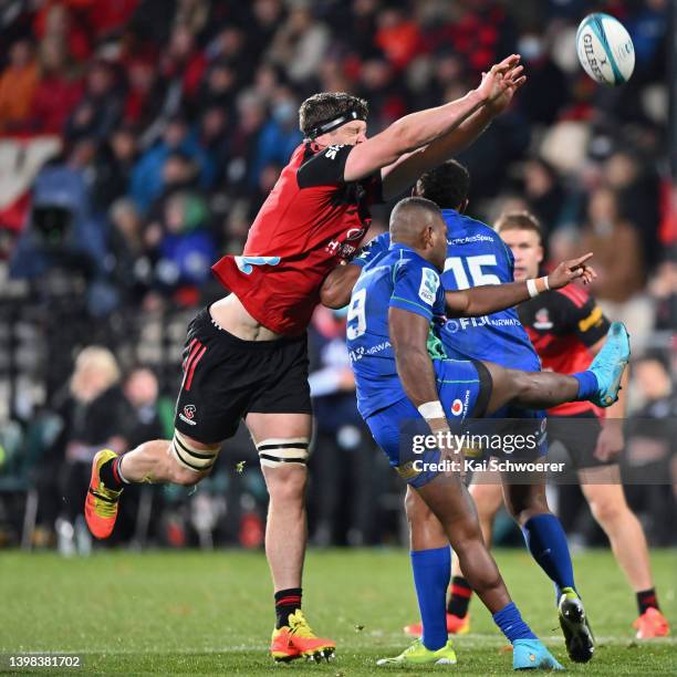 Scott Barrett of the Crusaders attempts to block a kick from Peni Matawalu of Fijian Drua during the round 14 Super Rugby Pacific match between the...